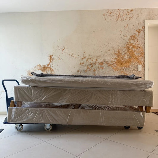 Verpacktes Bett auf einem Transportroller in einer leeren Wohnung