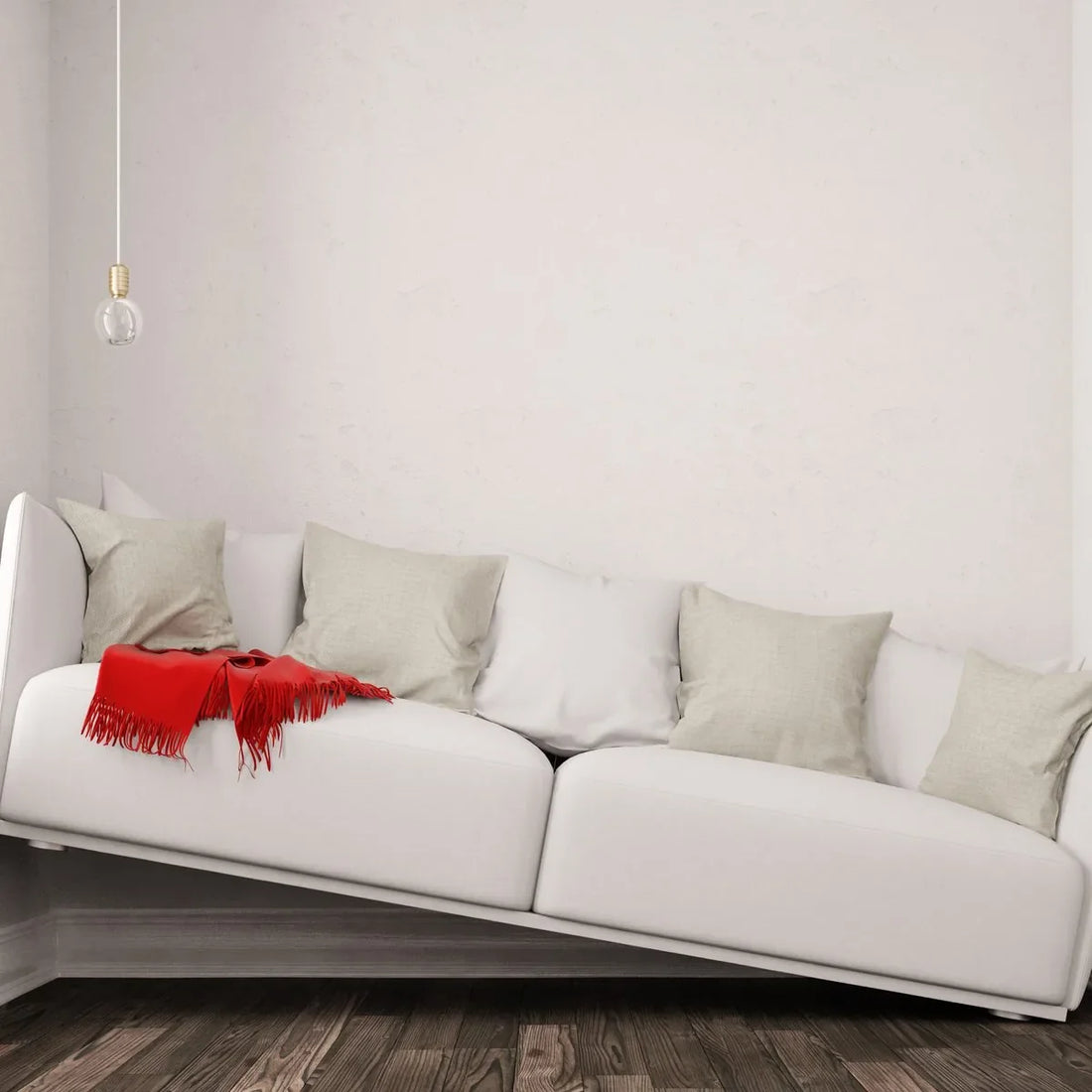 Weißes Sofa mit rotem Schal in einer leeren Wohnung