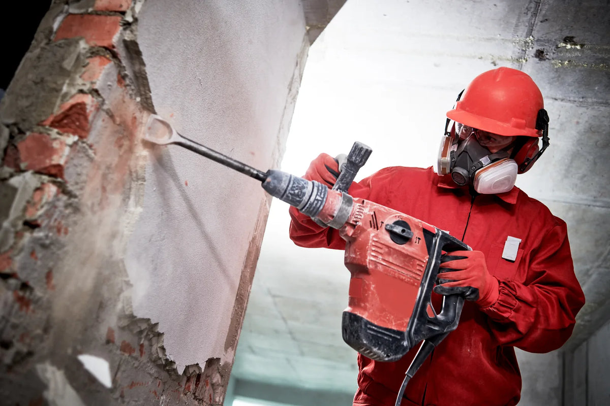 Handwerker mit Stemmhammer an einer Ziegelwand – Werkzeug mieten in Wien