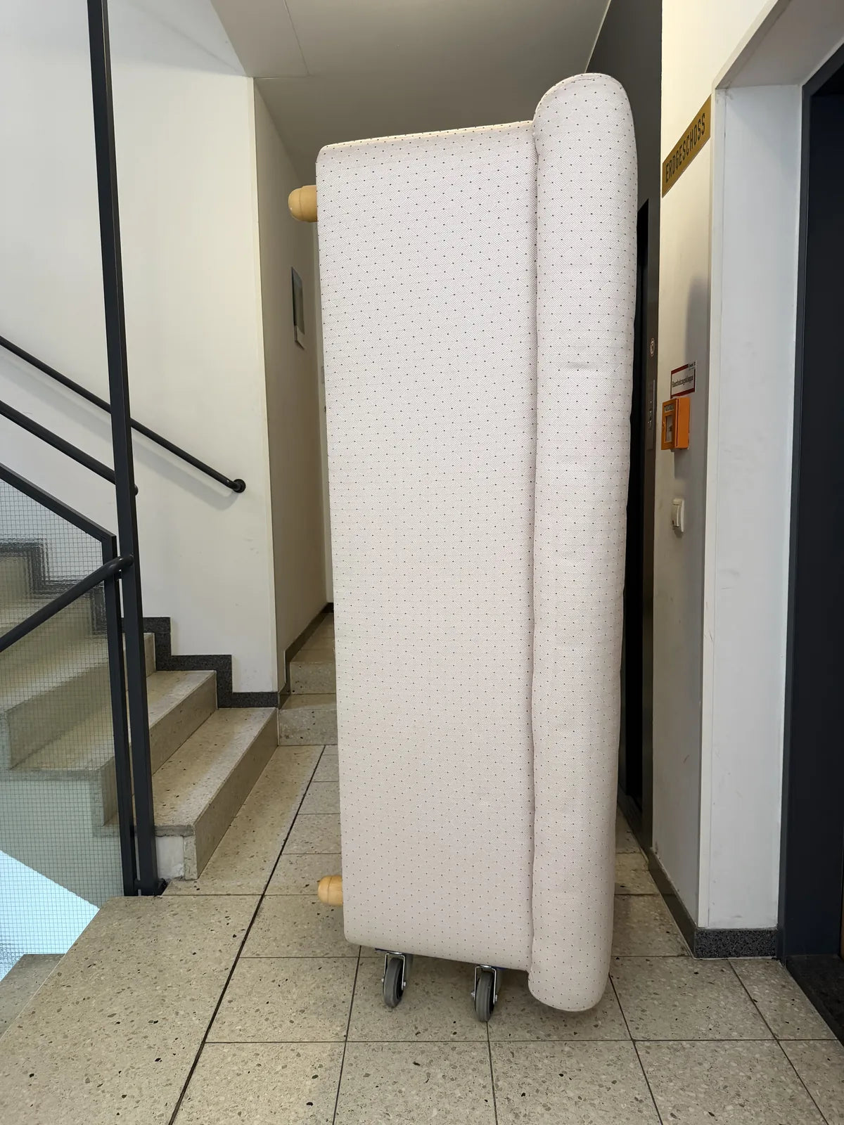 Sofa hochkant auf Möbelrollern im Stiegenhaus
